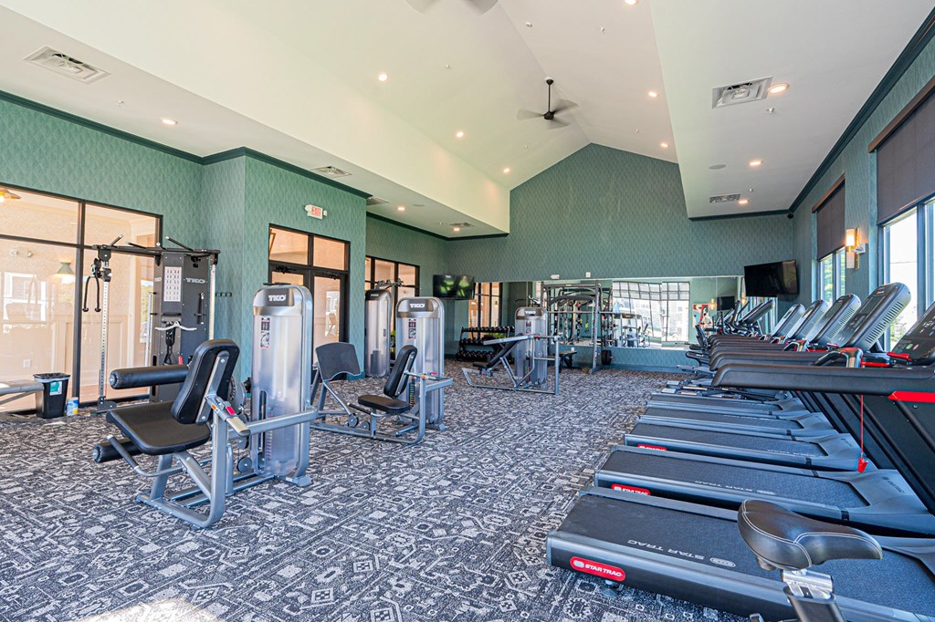 A gym with treadmills, elliptical machines, and other exercise equipment.