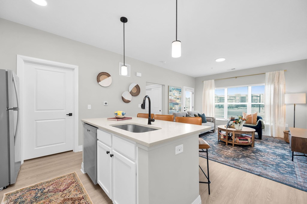 A modern kitchen with a white island and a rug on the floor.