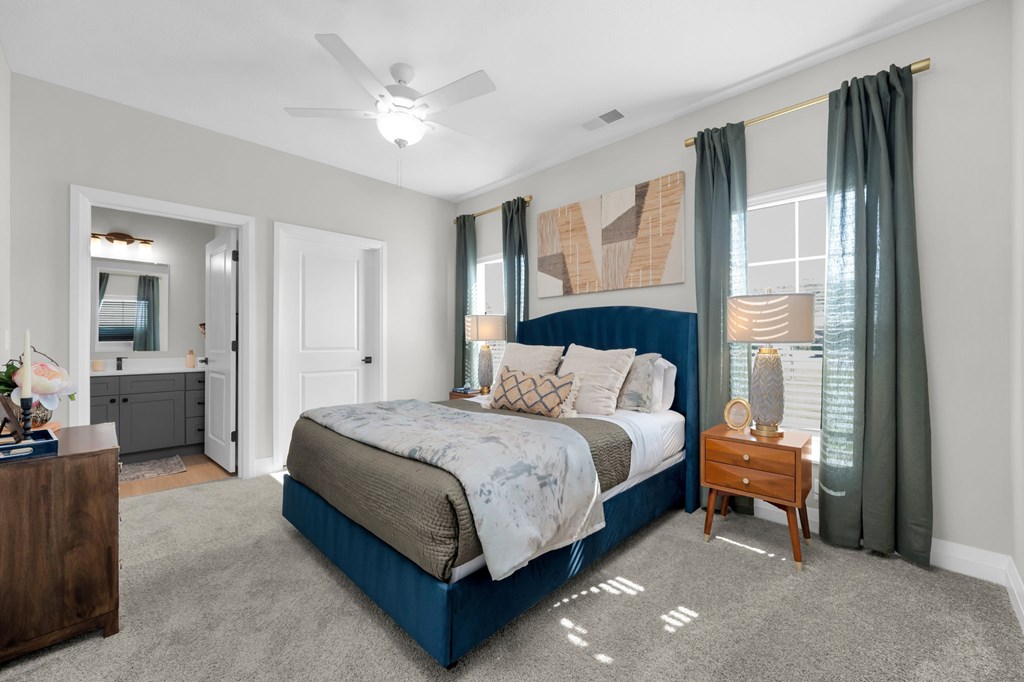 A bedroom with a large bed and a ceiling fan.