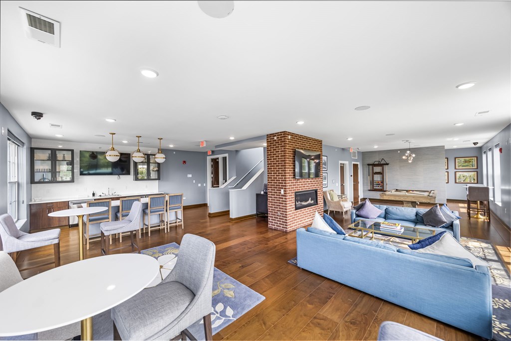 A living room with a white table and grey chairs.