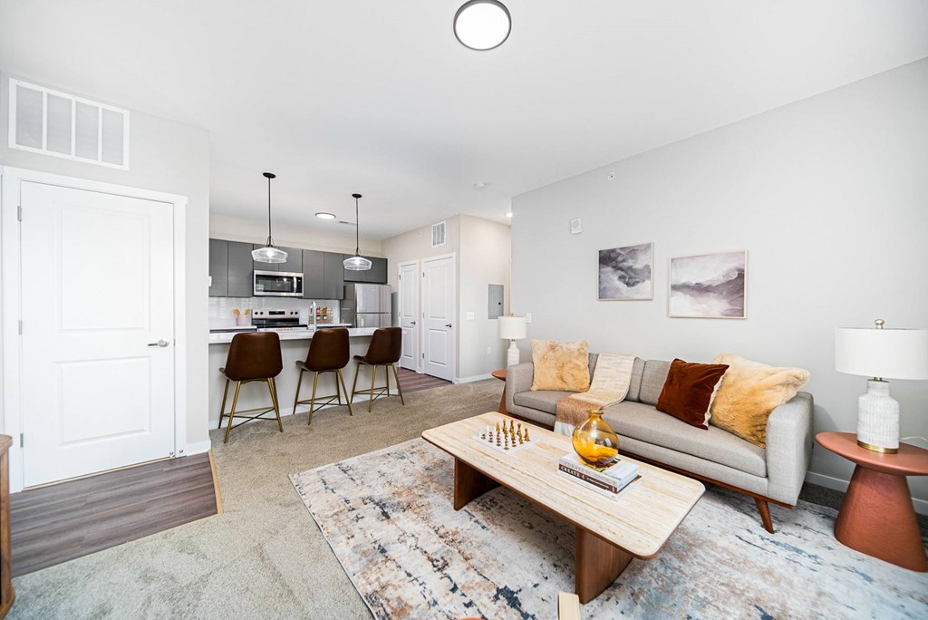 A living room with a grey couch and a wooden coffee table.