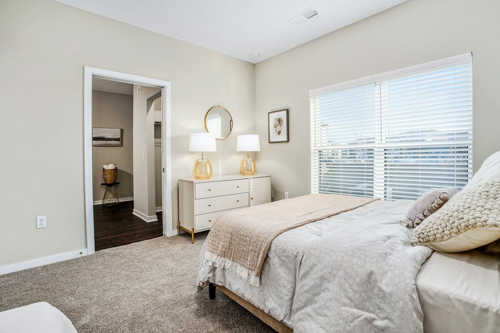 a bedroom with a bed and a large window