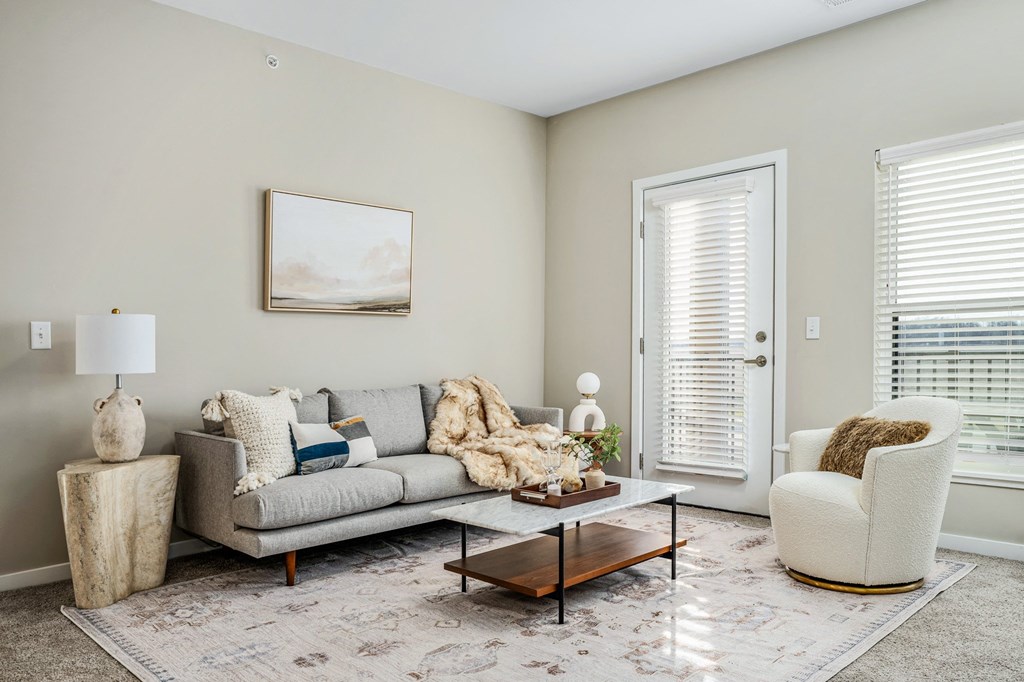 a living room with a couch and chairs and a coffee table