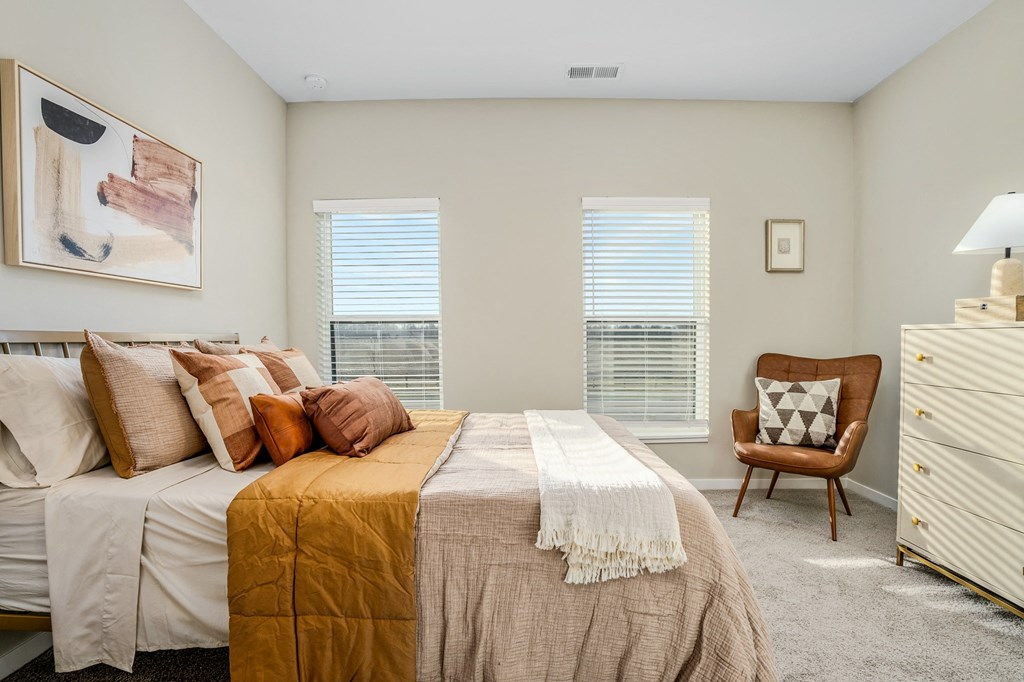 a bedroom with a bed and two windows