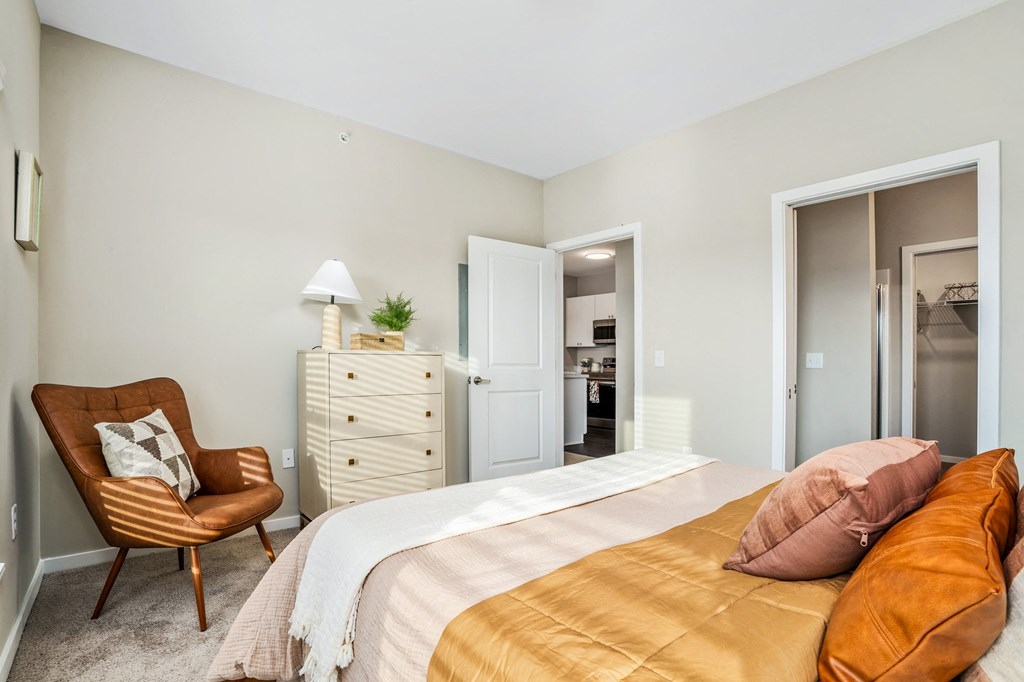 a bedroom with a bed and a chair and a closet