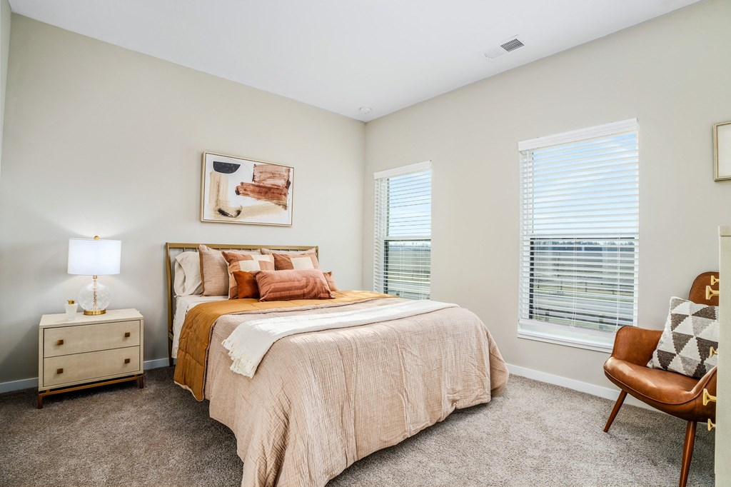 a bedroom with a bed and two windows