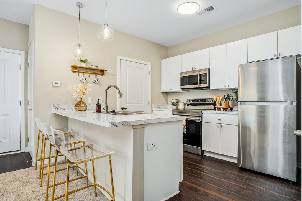 a kitchen with stainless steel appliances and a marble counter top