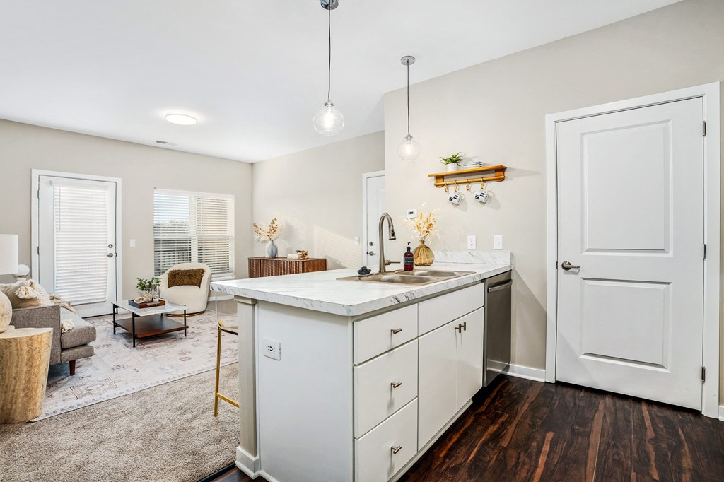 a renovated kitchen with white cabinets and a living room