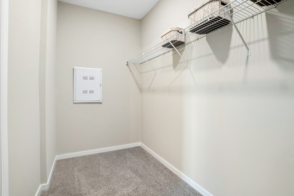 an empty closet with a wire basket hanging on the wall