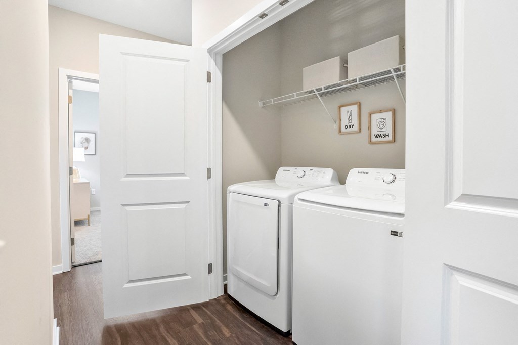 a spacious laundry room with washer and dryer and a door to the bathroom