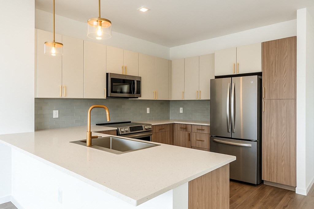 A kitchen with a white counter top and a stainless steel refrigerator.
