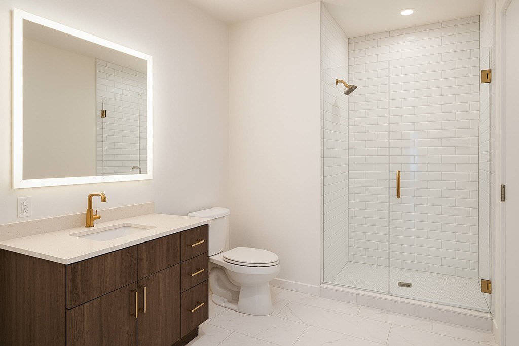 A white bathroom with a toilet, sink, and shower.