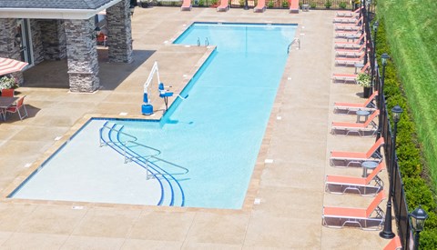 an aerial view of a swimming pool with chairs around it