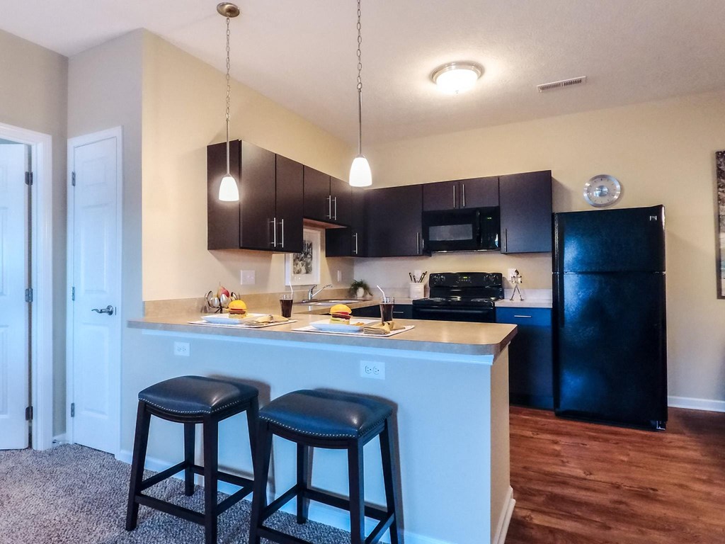 a kitchen with a large island with two stools in front of it