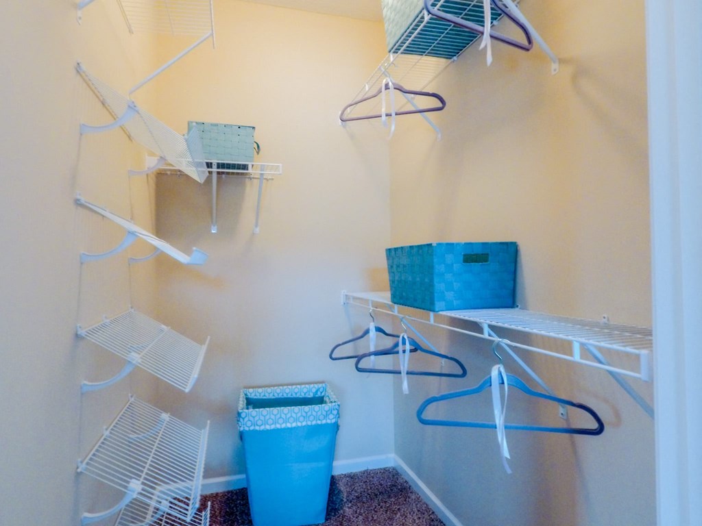a walk in closet with shelves and a basket