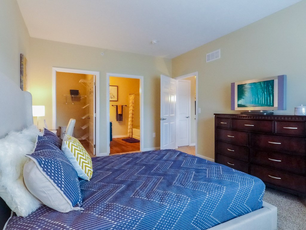 a bedroom with a large bed and a dresser