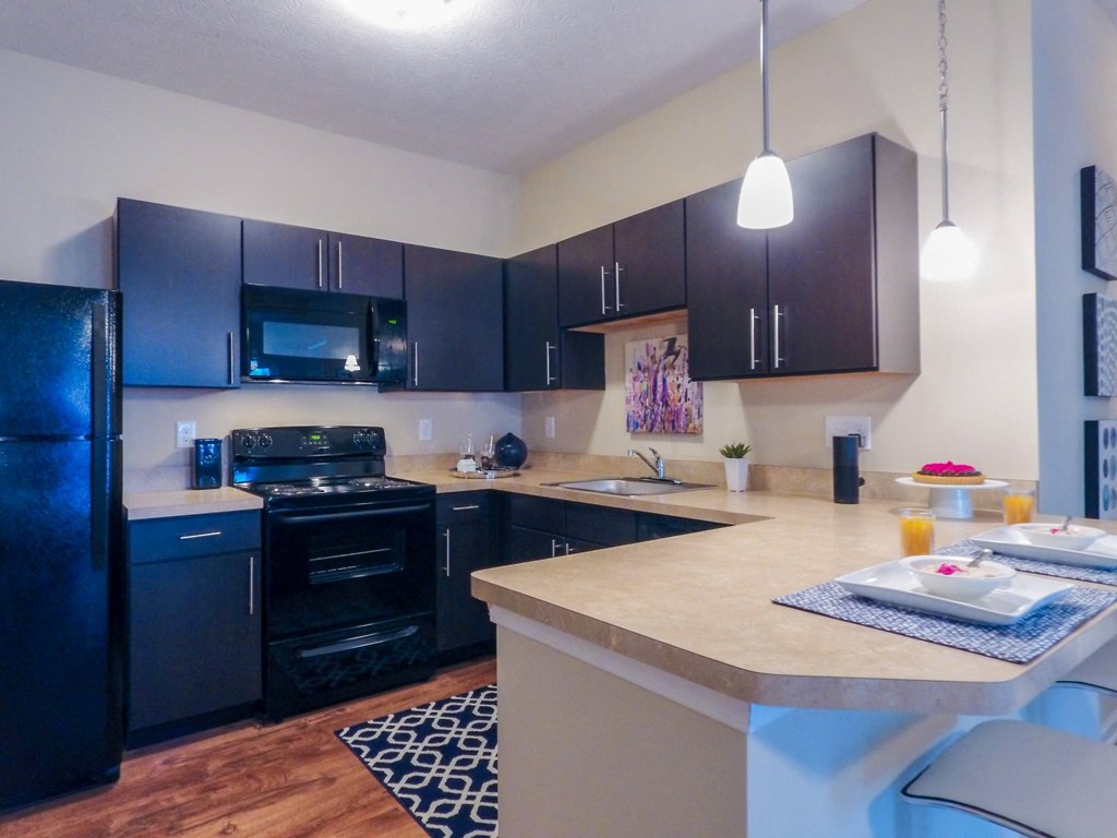 a kitchen with black cabinets and a white island with a breakfast bar