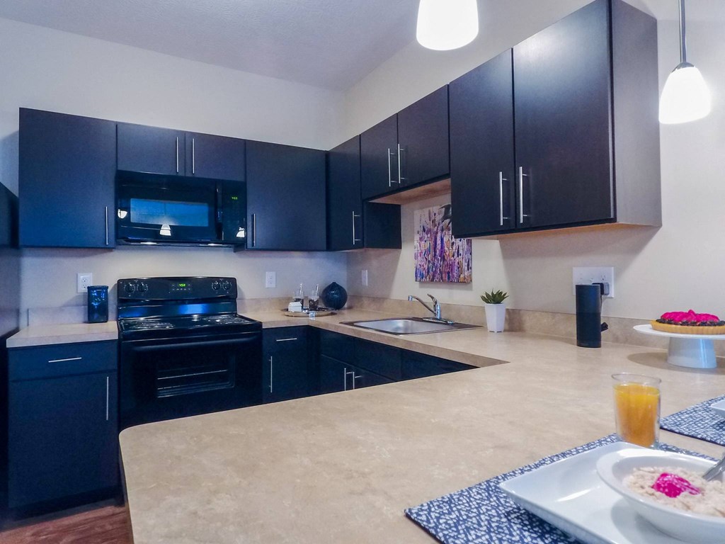 a kitchen with black cabinets and a white counter top