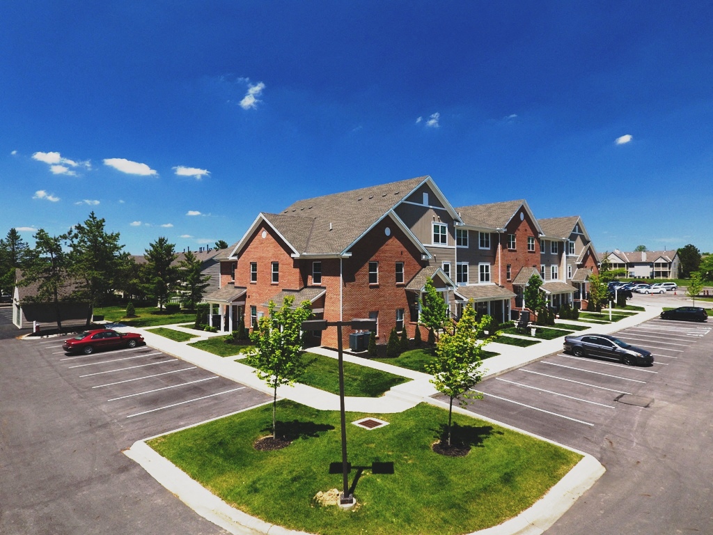 a row of houses in a parking lot with trees