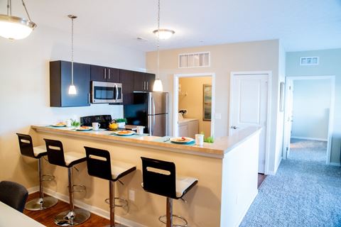 a kitchen with a large island with stools in front of it