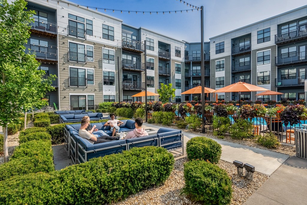 people sitting on a couch in an outdoor courtyard at an apartment building