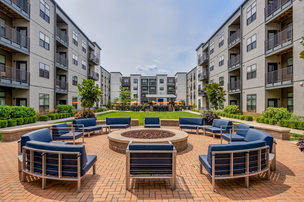 an outdoor lounge area with a fire pit at an apartment complex