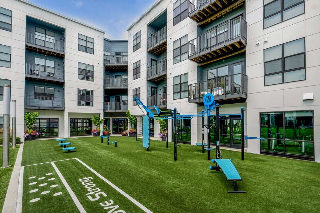 an apartment building with a playground and benches in front of it