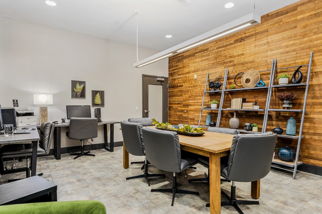 a dining room with a wooden table and chairs and a desk with a computer