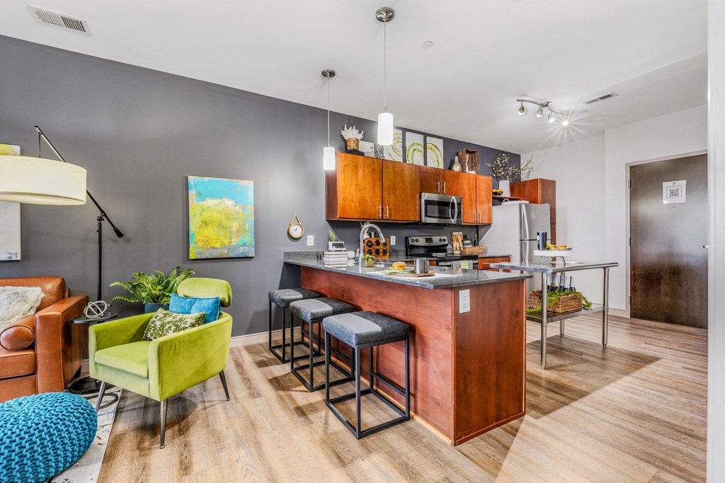 a kitchen with a bar and a living room with a couch