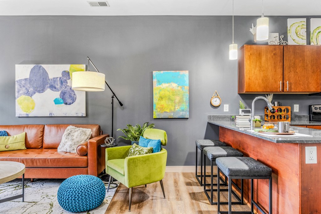 a living room with a kitchen and a couch and chairs