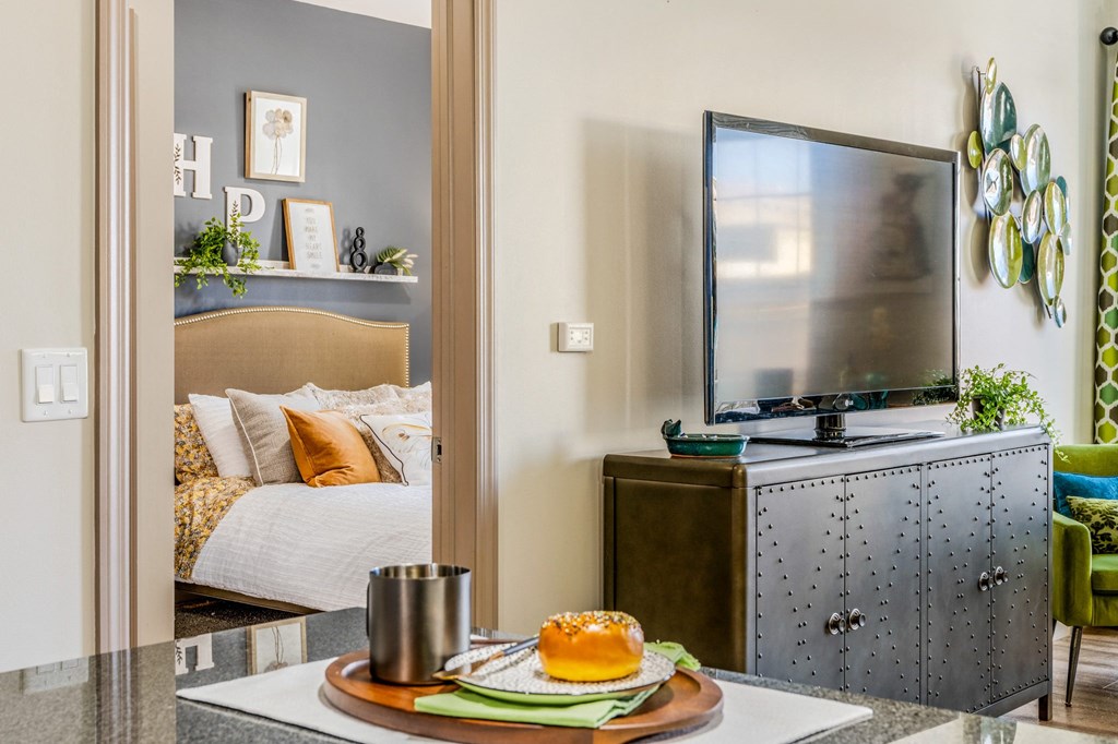 a bedroom with a tv and a table with a plate of food