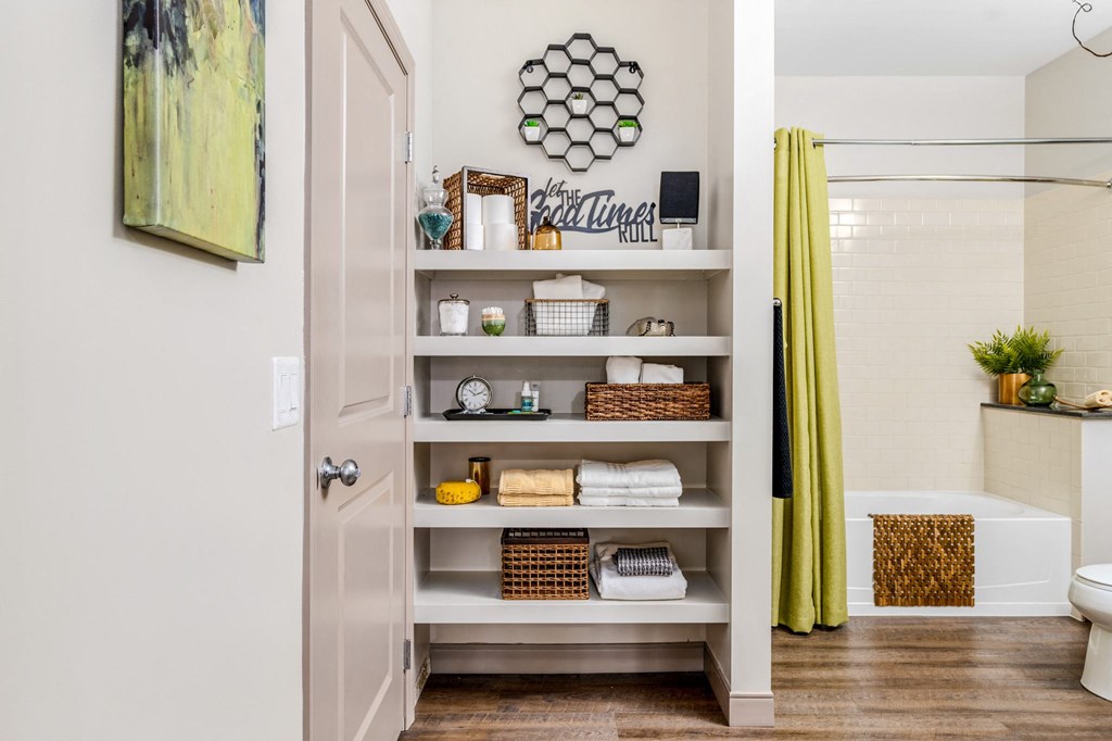a bathroom with shelves and a shower and a yellow curtain