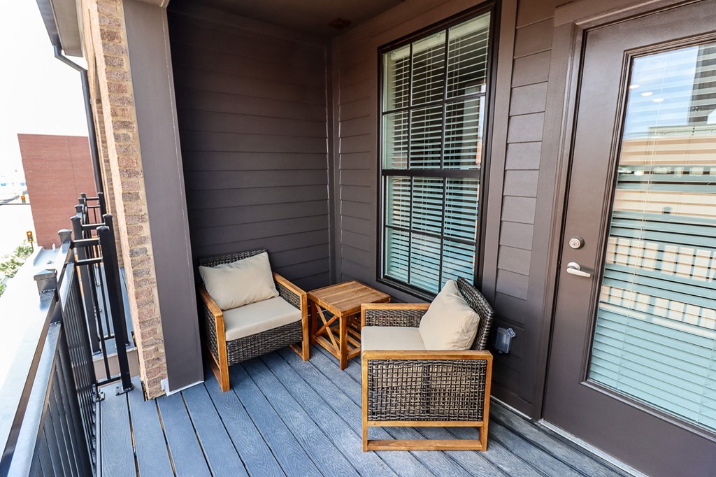 a balcony with two chairs and a table