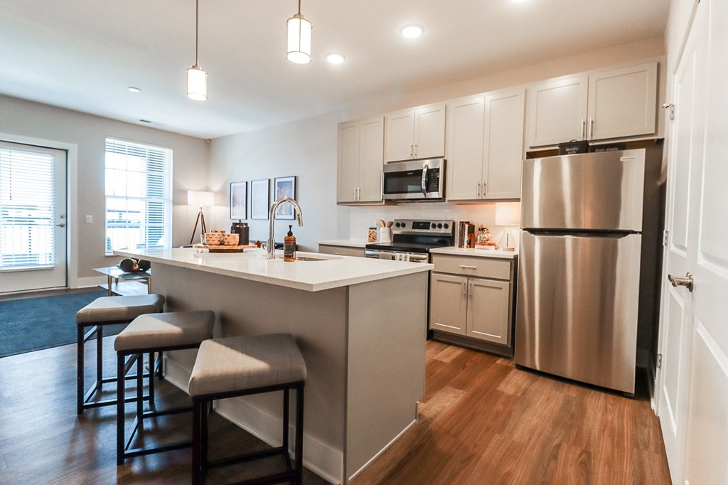 a kitchen with a large island and stainless steel appliances