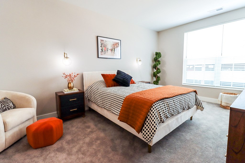 a bedroom with carpeted floors and a large window