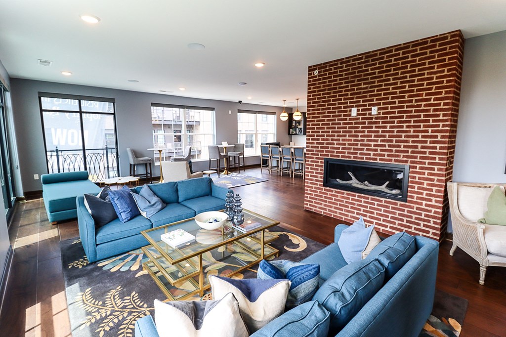 a living room with blue couches and a coffee table in front of a fireplace