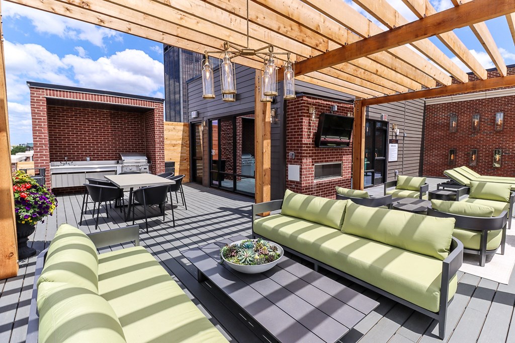 a patio with a wooden pergola and a table and chairs