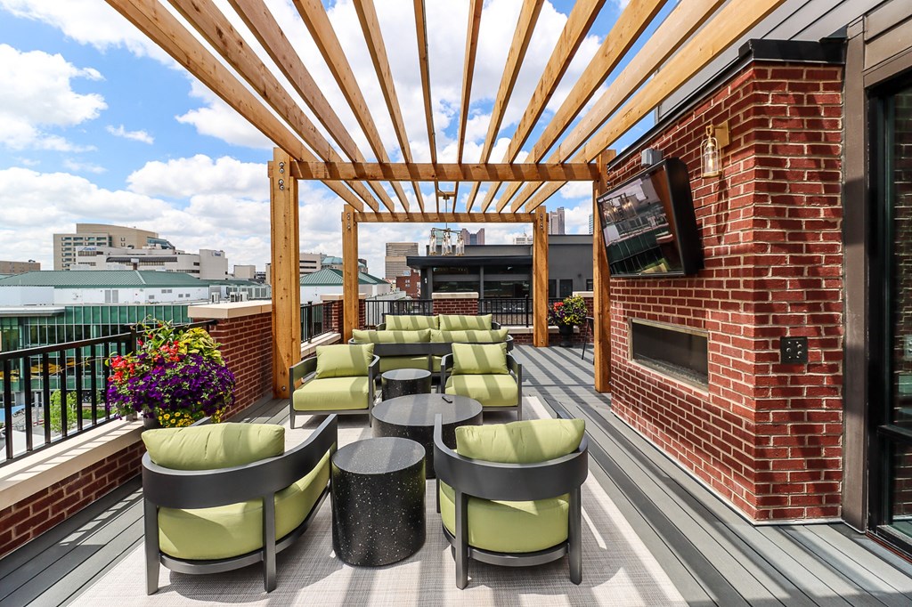 an outdoor patio with a television and tables and chairs