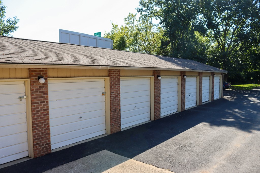 a row of white garage doors on a brick building