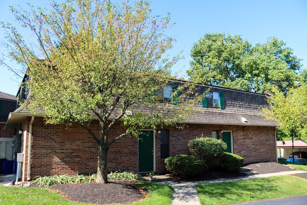 a brick house with a tree in front of it