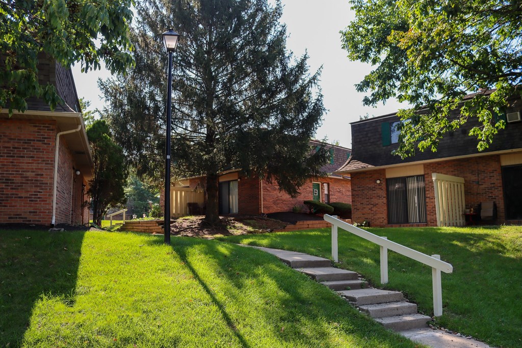a house with a white fence and stairs in front of it