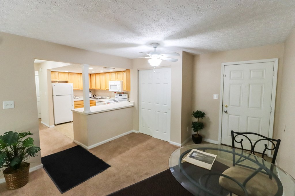 an open kitchen and living room with a glass table