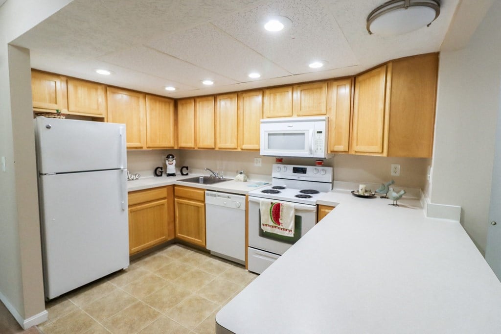 a kitchen with white appliances and wooden cabinets
