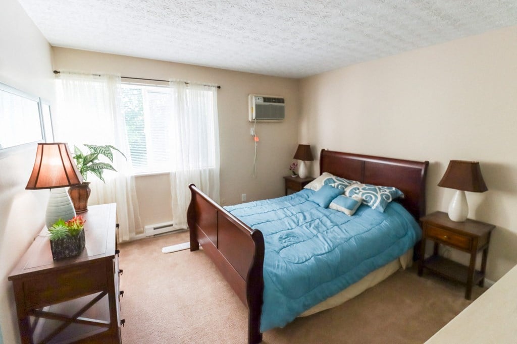 a bedroom with a bed and a dresser and a window