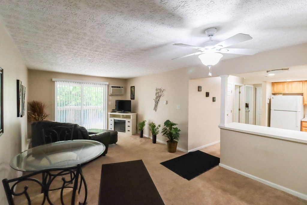 an open living room with a kitchen and a ceiling fan
