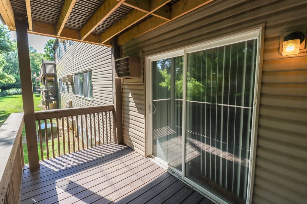 a covered porch with glass doors on a house