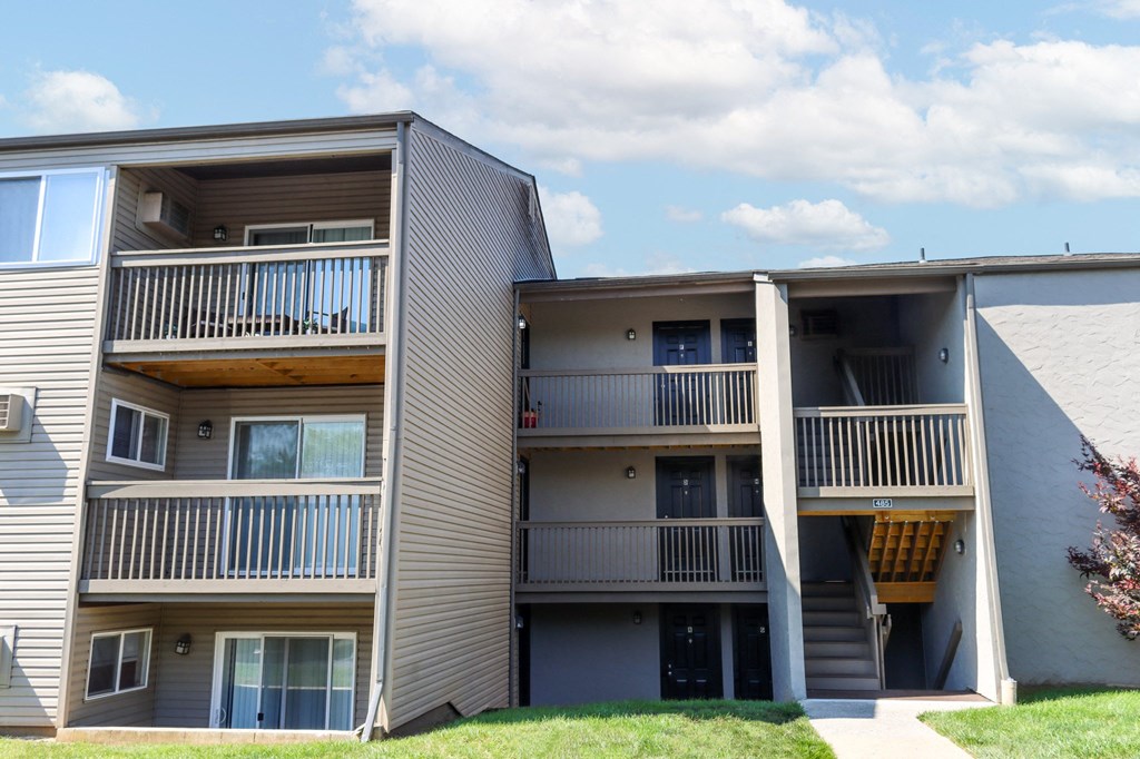 a view of two apartment buildings with balconies and a lawn