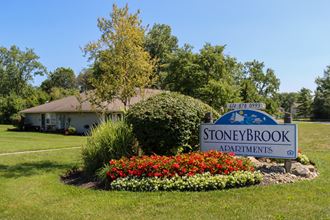 the sign for stoneybrook in front of a garden with colorful flowers