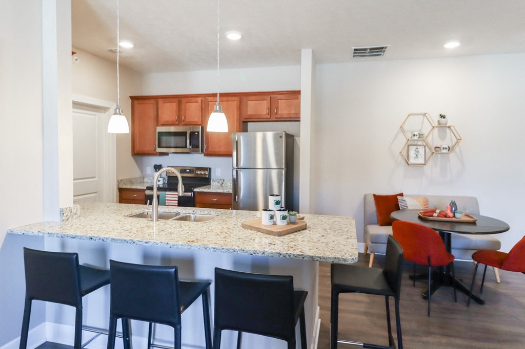 a kitchen and dining area with a granite counter top and stainless steel appliances