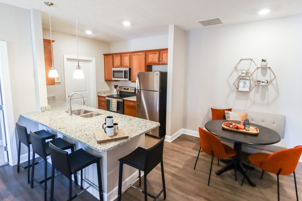 a kitchen and dining area with a granite counter top and stainless steel appliances